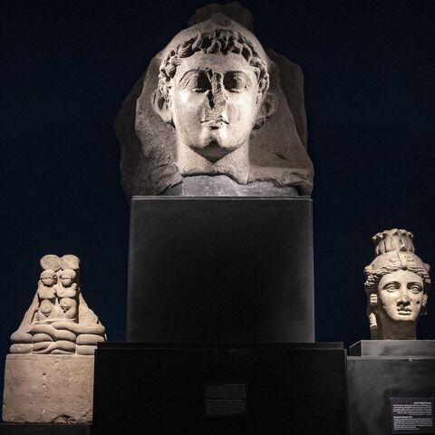 A visitor views the busts of Cleopatra VII Thea Philopator.