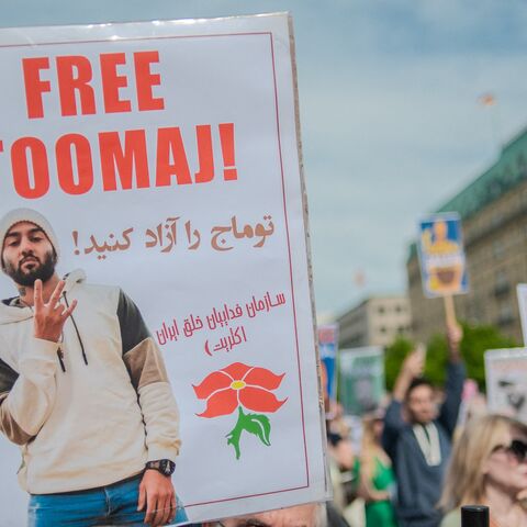 Protesters hold signs during a rally protesting against a death sentence given to Toomaj Salehi, a famous Iranian rapper, in Berlin, Germany, on April 28, 2024. 