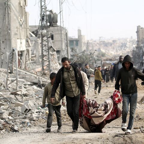 Palestinian men carry a body retrieved from under the rubble following their return to Nuseirat, in the central Gaza Strip, after Israeli shelling of the camp stopped, Nov. 29, 2024.