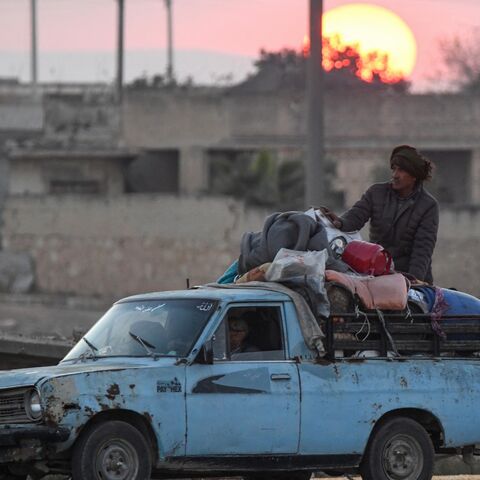 Displaced Syrian Kurds drive a vehicle loaded with belongings on the Aleppo-Raqqa highway.