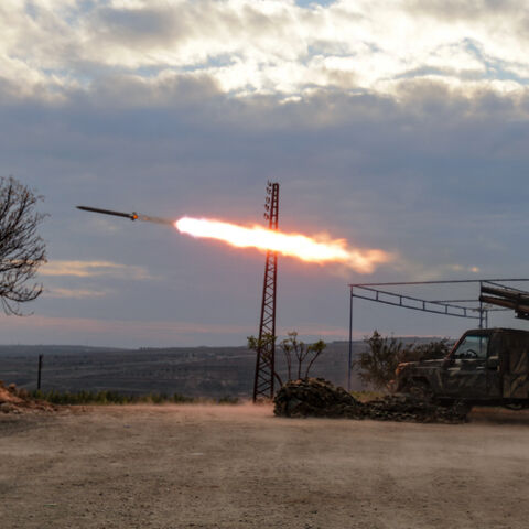 An anti-government fighter covers his ears as a multi-barrel rocket launcher fires against regime forces, in the northern outskirts of Syria's west-central city of Hama on Dec. 4, 2024.