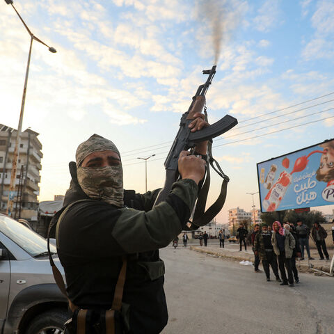 A Syrian anti government fighter fires his rifle into the air in the streets of the west-central city of Hama on Dec. 5, 2024.