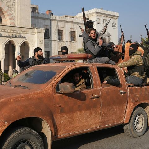 Syrian anti-government fighters celebrate as they pour into the captured city of Hama, Dec. 6, 2024.