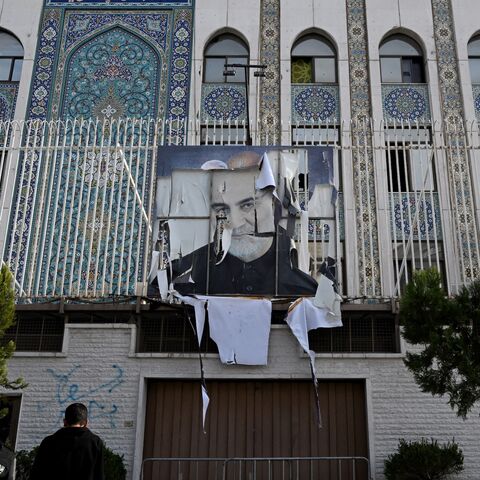 Syrian men stand outside the building of the Iranian Embassy.