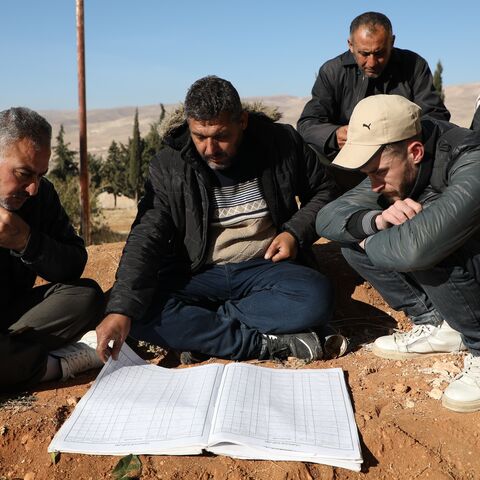 People examine documents at Sednaya Prison, where thousands of people were said to be detained and tortured by the Assad regime.