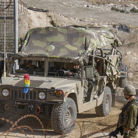 Israeli military vehicles cross the fence as they return from the buffer zone with Syria.