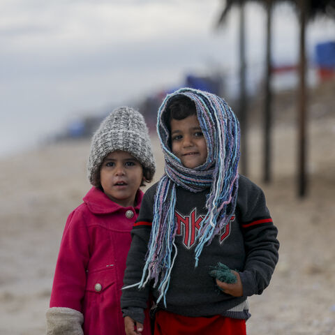 Children stand on a beach in Deir al-Balah, Gaza Strip, on December 30, 2024. The severe storms have caused significant damage to the already fragile living conditions in the camp. (Photo by Youssef Alzanoun / Middle East Images / Middle East Images via AFP) (Photo by YOUSSEF ALZANOUN/Middle East Images/AFP via Getty Images)