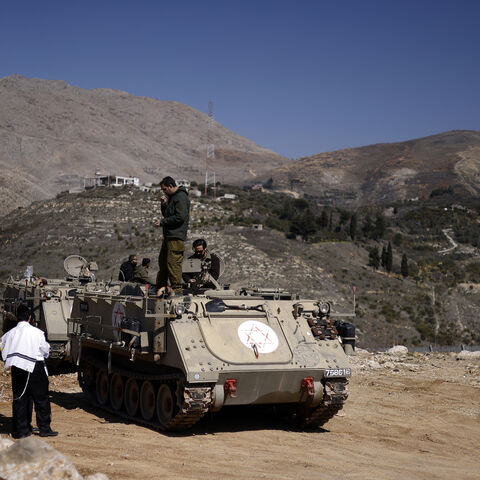 Ultraorthodox Jewish men speak to soldiers standing on an armored personnel carrier in the buffer zone that separates the Israeli-annexed Golan Heights and Syria, near the Druze village of Majdal Shams, Feb. 27, 2025.