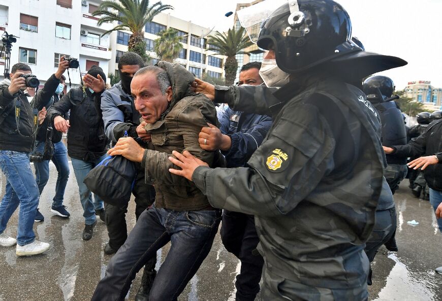 A Tunisian man is arrested following clashes with police during protests against President Kais Saied, on the 11th anniversary of the Tunisian revolution
