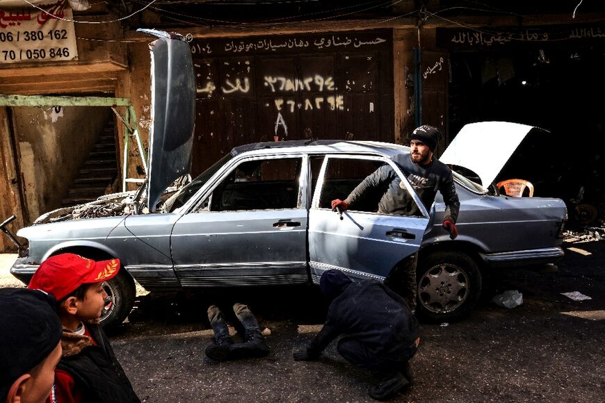 Mechanics repair a car in an alley of Tripoli's impoverished neighbourhood of Bab al-Tabbane
