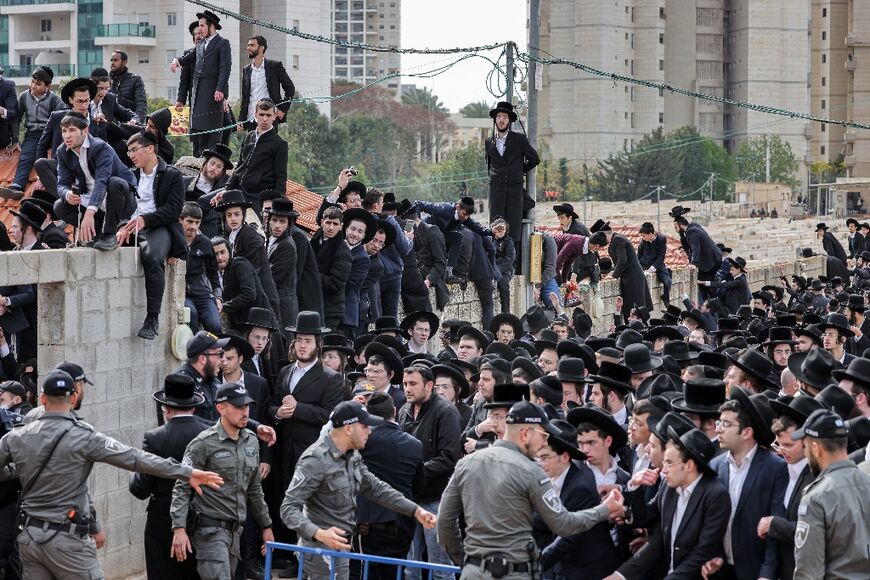Israeli security forces enforce a perimeter before ultra-Orthodox Jewish mourners 