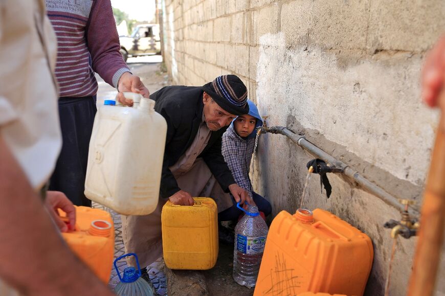 Yemenis fill their jerrycans with drinking water from a donated tank amid acute shortage in the capital Sanaa on March 31, 2022