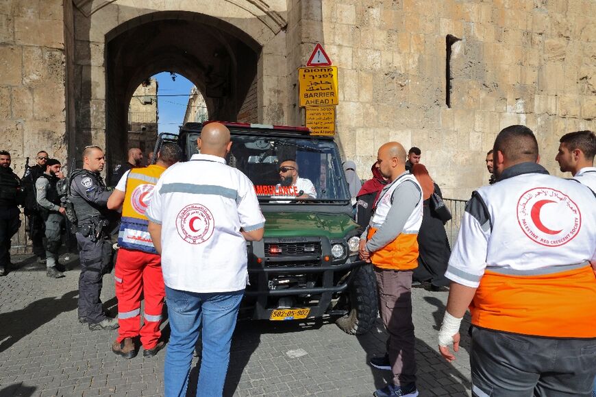 Members of Israeli security stop and search a Palestinian Red Crescent ambulance transporting an injured man at Jerusalem Old City's Lions' Gate