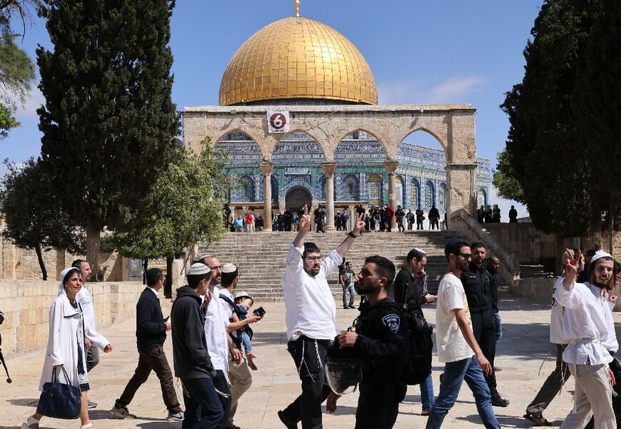 Israeli police accompany a group of Jewish visitors past the Dome of the Rock mosque at the Al-Aqsa mosque compound in the Old City of Jerusalem