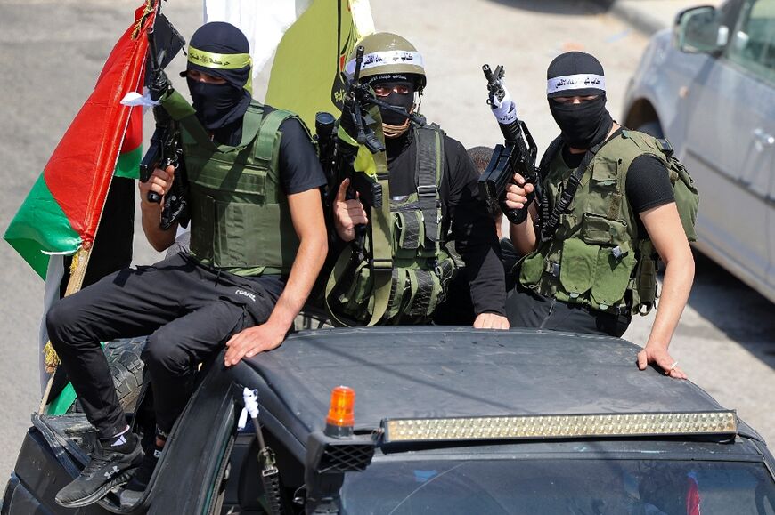 Armed Palestinian fighters joined the funeral procession of the three men killed in an Israeli army raid