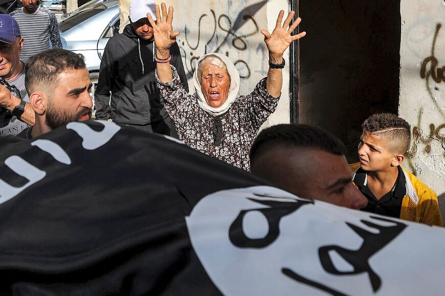 A Palestinian woman grieves as pallbearers carry the body of Baraa Lahluh. Hamas said he was a local commander in the Israeli-occupied West Bank