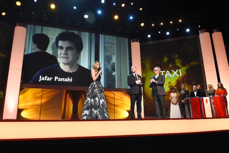 In this file photo taken on February 14, 2015 German actress Anke Engelke (L) speaks near a giant portrait of Iranian  director Jafar Panahi, as the Golden Bear for Best Film goes to Panahi at the Berline International Film Festival
