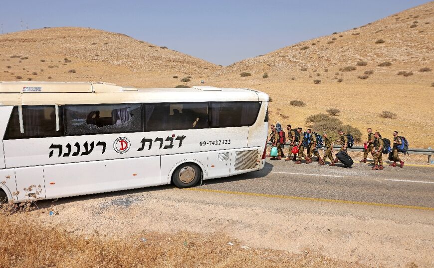 Israeli soldiers carrying belongings after the attack