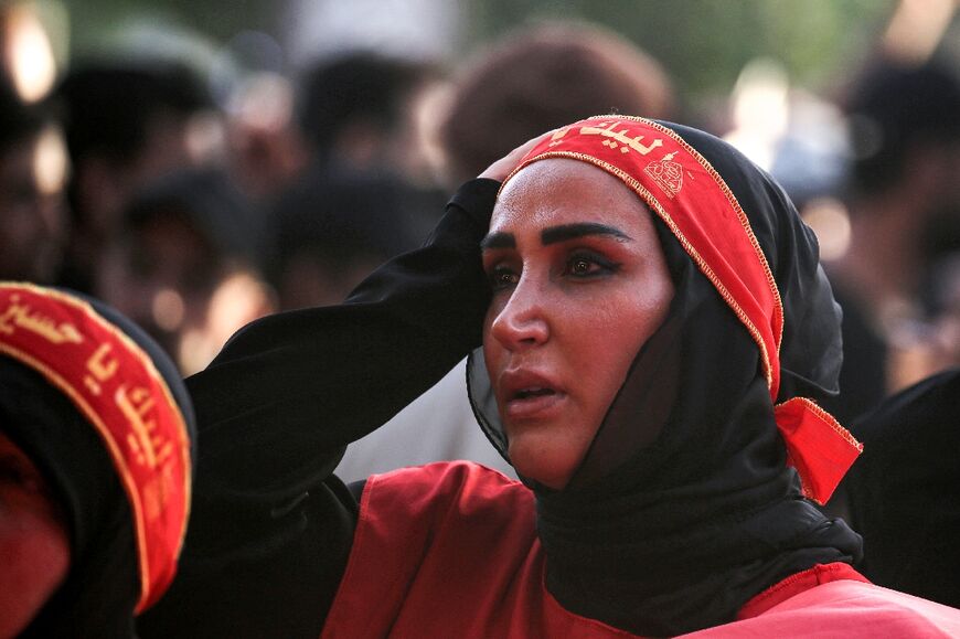A woman looks on as Shiite Muslim devotees gather in Iraq's central holy shrine city of Karbala, marking 40 days after the holy day of Ashura