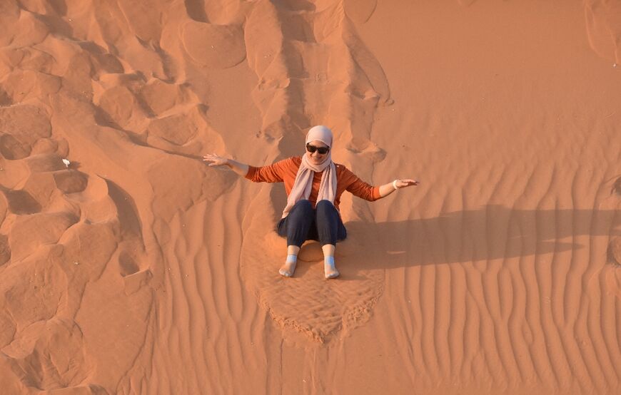 A woman surfs down a sand dune in the "Saed" desert area, 110 kilometres east of Riyadh