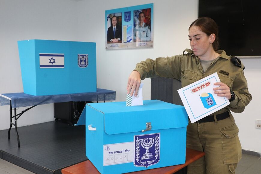 An Israeli soldier casts her ballot for the general elections at a military base in the city of Ashdod on October 30, 2022