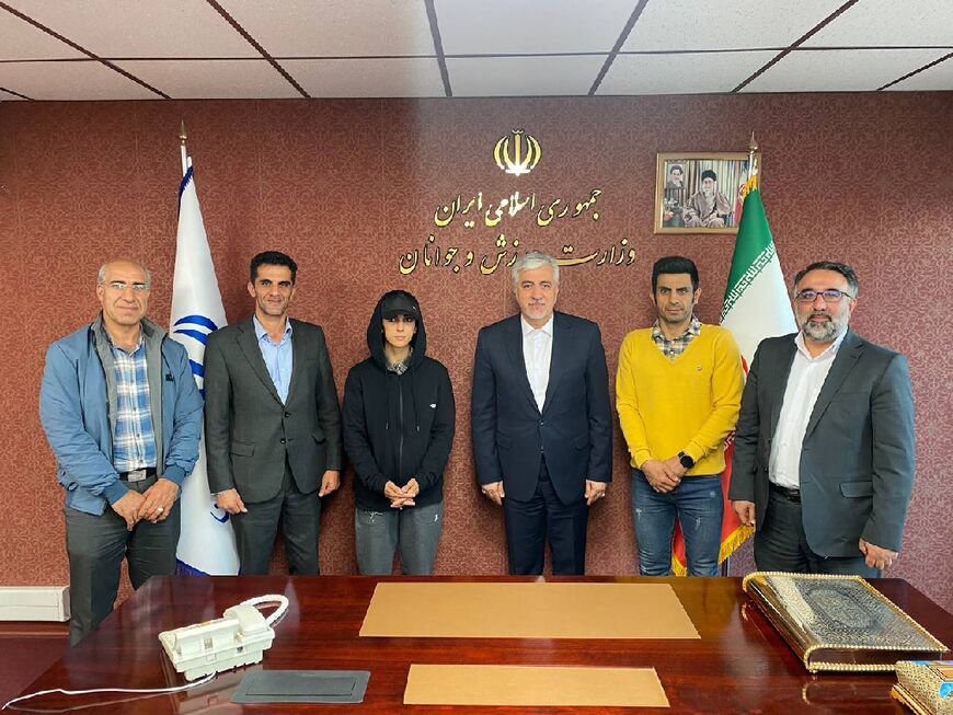 An official sports ministry picture shows Iran's Minister of Youth Affairs and Sports Hamid Sajjadi (C-R) meeting with Iranian climber Elnaz Rekabi (C-L) in Tehran on Wednesday