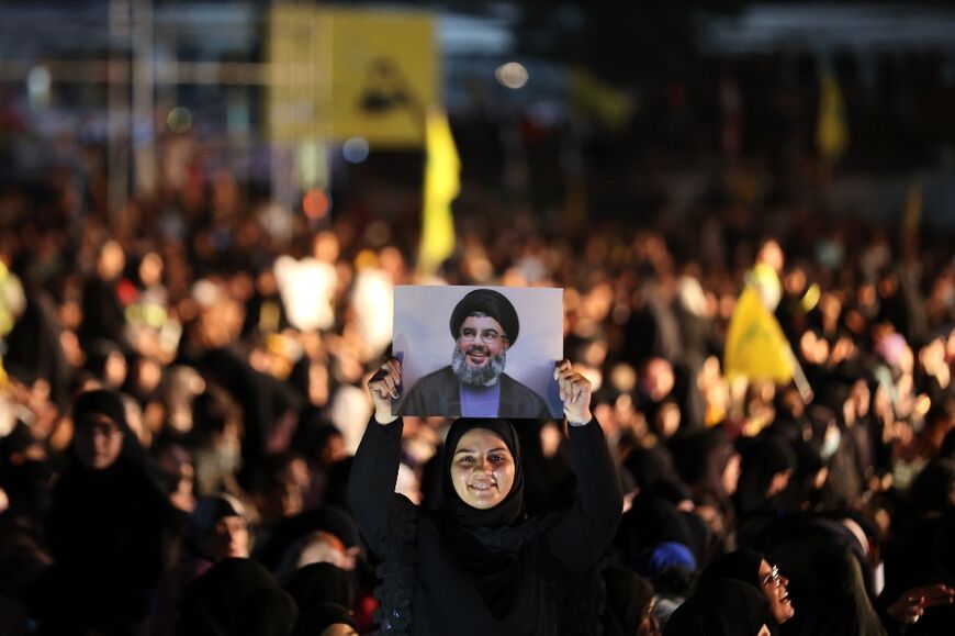 A supporter of Hezbollah holds up a portrait of leader Hassan Nasrallah during a celebration marking the 40th anniversary of the Shiite movement creation in southern suburb of Beirut on August 22, 2022