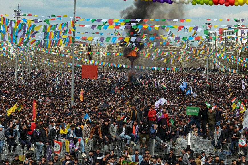 Turkish Kurds gather around a bonfire in Diyarbakir, southeastern Turkey, on March 21, 2022, to celebrate Nowroz, an ancient Persian festival also celebrated by Kurdish people and other groups marking the first day of spring