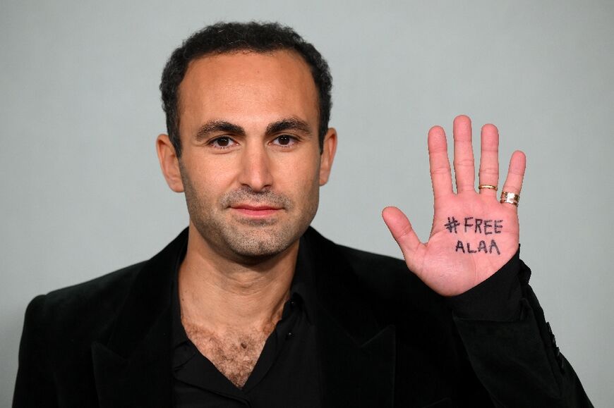 Egyptian-British actor Khalid Abdalla, with the words 'Free Alaa' on his hand poses on the red carpet upon arrival at the World Premiere of "The Crown (Season 5)" in London on November 8, 2022