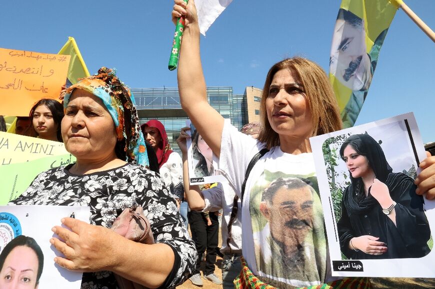 Kurdish women raise flags bearing the portrait of the Kurdistan Worker's Party (PKK) leader Abdullah Ocalan, as they demonstrate in Beirut in solidarity with women-led protests in Iran sparked by the death of Kurdish woman Mahsa Amini