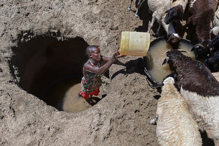 A young Kenyan woman from the Turkana community waters goats from a shallow well : nations worldwide are coping with increasingly intense natural disasters that have taken thousands of lives  
