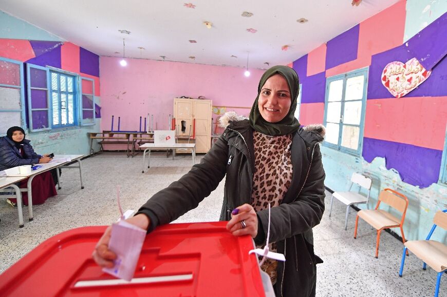 A Tunisian voter casts her ballot at a polling station in Mnihla district, outside of Tunis 
