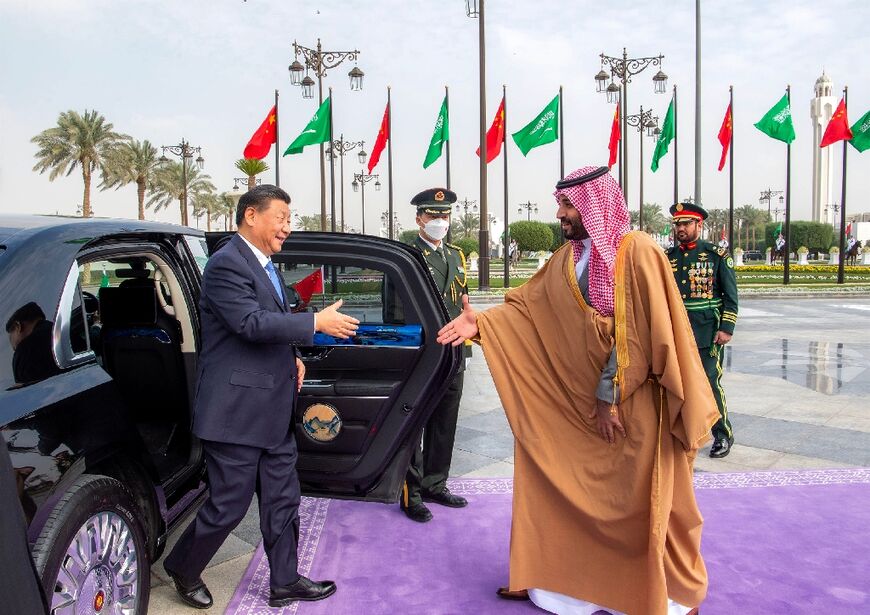 China's President Xi Jinping (L), greeted by Saudi Arabia's de facto ruler Crown Prince Mohammed bin Salman, is visiting during tensions between the kingdom and the United States