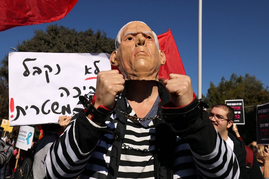 An Israeli activist wears a mask of Prime Minister-designate Benjamin Netanyahu during a protest outside the Knesset against the right-wing government set to be sworn in