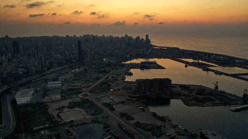 This picture taken on October 11, 2021 shows a dusk aerial view of the devastated port area of Lebanon's capital Beirut, in darkness during a power outage 