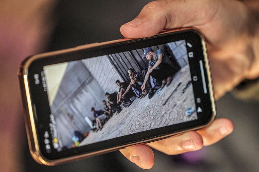 Yunis al-Shaer, sitting at right, in Libya, is pictured on his brother's mobile phone