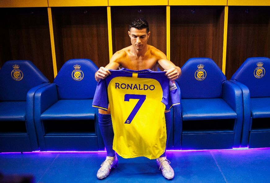 An Al-Nassr handout photo shows Cristiano Ronaldo preparing to put on his club shirt before being introduced to fans at the club's Mrsool Park stadium
