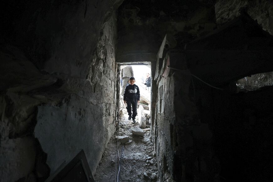 A boy walks inside the partly demolished house in the Old City of Nablus