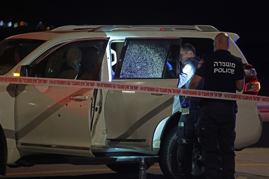 Israeli security forces examine a bullet-riddled vehicle in which an Israeli-American was killed