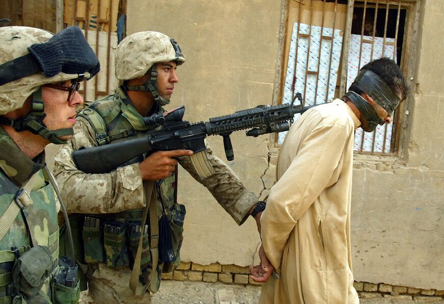 US Marines arrest an Iraqi man during a house-to-house search in the Jolan district of the restive city of Fallujah, in this file photo from November 12, 2004 