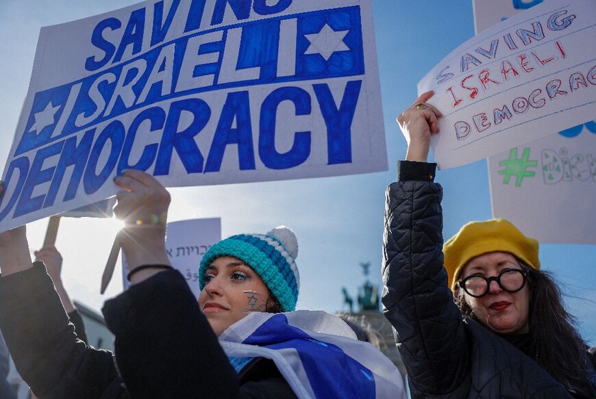 Demonstrators protest in front of Berlin's Brandenburg Gate against the policies of visiting Israeli Prime Minister Benjamin Netanyahu