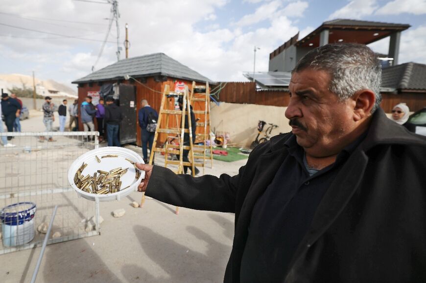 A man shows cartridge casings after the raid in which Thayer Aweidat was initially reported killed