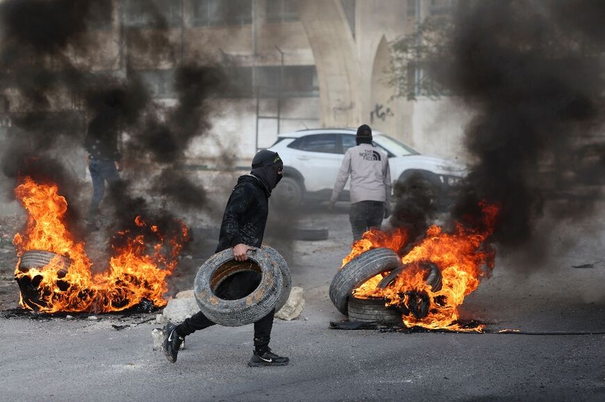 Palestinian protesters burned tyres after the Israeli raid at the entrance to Aqabat Jabr refugee camp