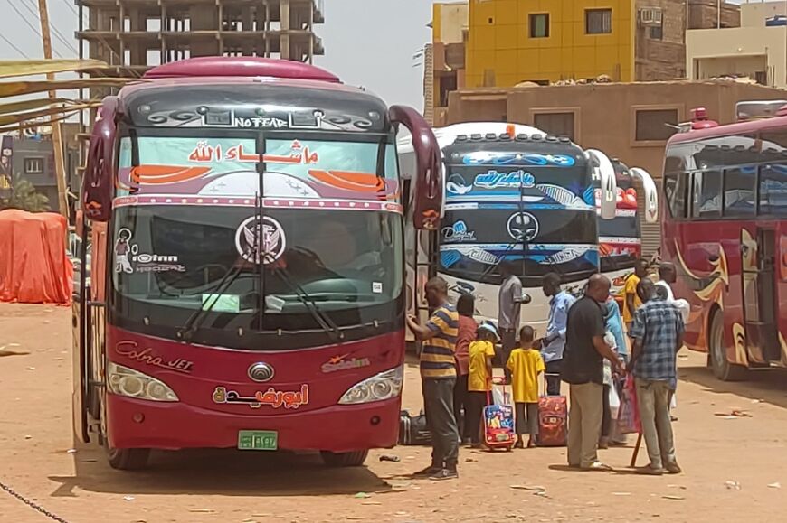 Sudanese civilians wait to board buses out of the capital Khartoum as heavy fighting between rival security forces shows no let-up