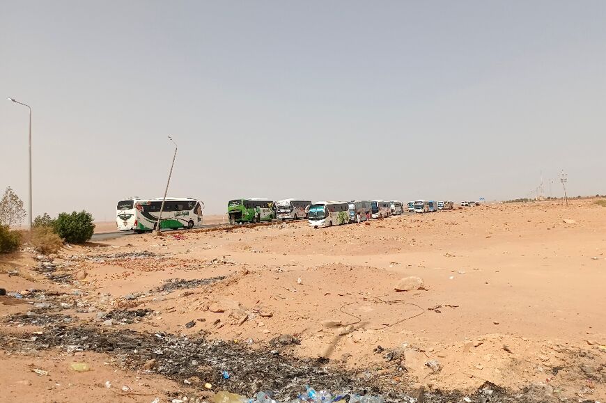 A bus convoy from war-torn Sudan arrives at the Wadi Karkar bus station near the Egyptian city of Aswan, on April 25, 2023