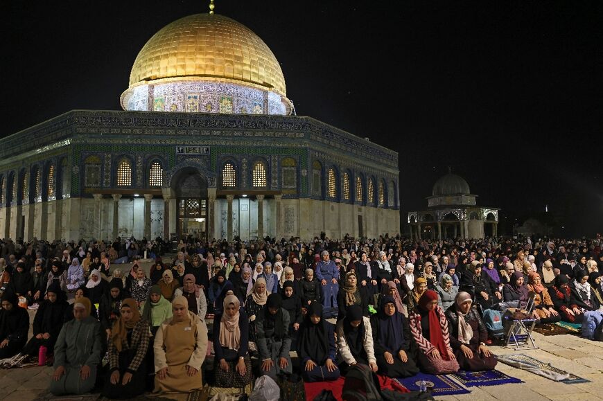 Palestinians pray outside the Dome of the Rock in Jerusalem's Al-Aqsa Mosque compound