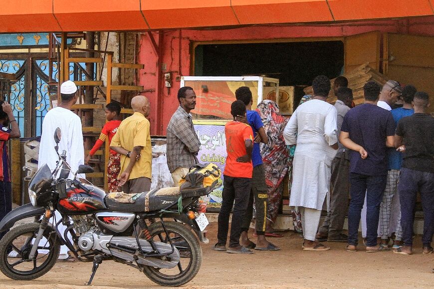 People queue for bread outside a bakery in Khartoum amid food shortages