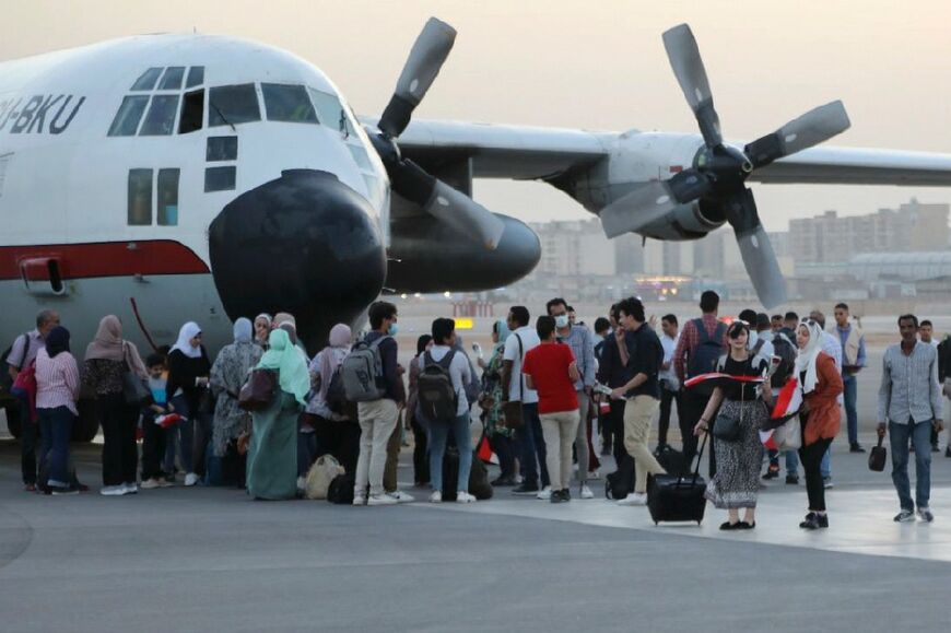 Egyptian evacuees from Sudan disembark upon landing in Cairo
