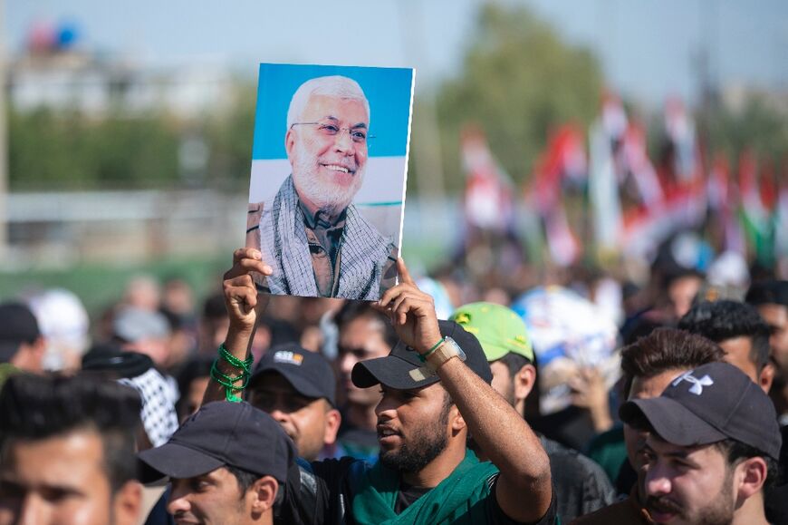 An Iraqi carries a poster bearing the of portrait of slain Iraqi commander Abu Mahdi al-Muhandis during rallies in support of the Palestinian people on Friday