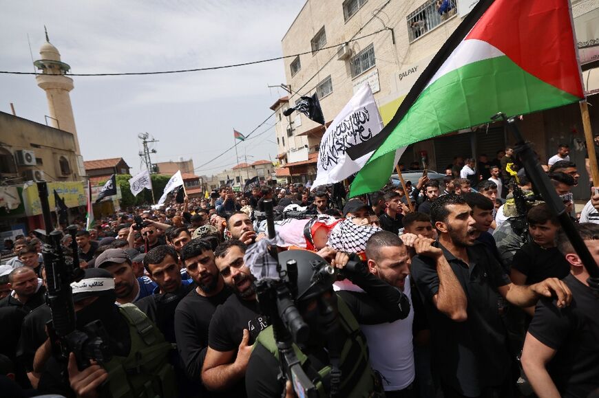 Palestinian mourners, some of them armed, at the funeral for Ayed Slim, shot dead by Israeli police in the West Bank
